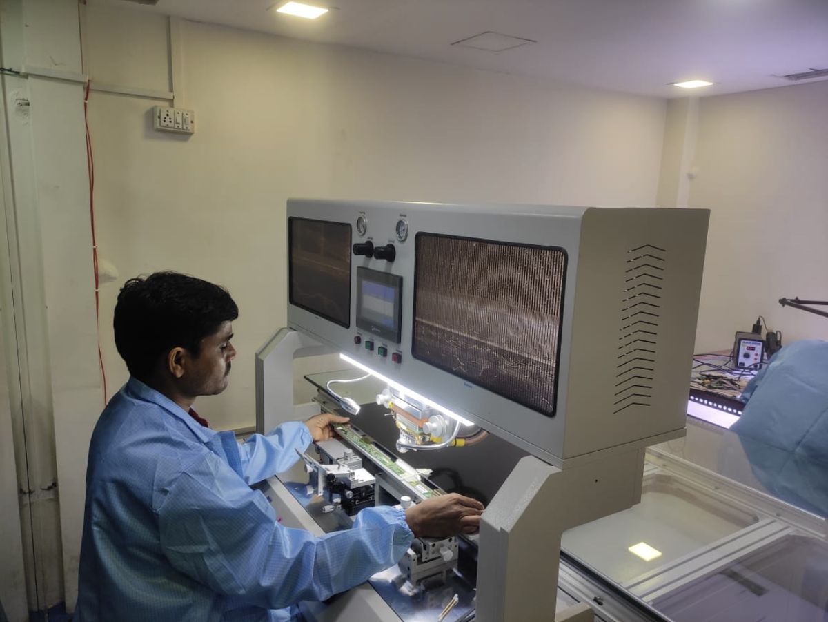 Technician operating the panel-bonding machine at Braviaa Services